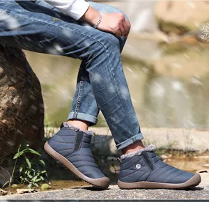Deep blue quilted winter snow boots with warm faux fur lining on a rock surface