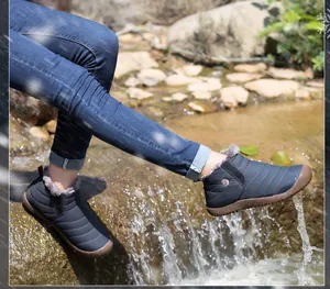 Outdoor snow boots with waterproof fabric showing water resistance by a stream