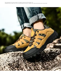 Detailed view of yellow pigskin hiking shoes with grippy rubber soles on outdoor rocks