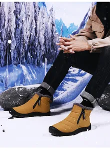 Close-up of yellow winter snow boots with side zipper and warm faux fur lining on snow