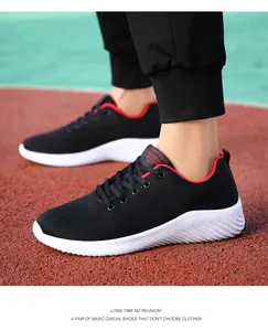 Detalle de zapatilla de running de malla negra con suela blanca en pista de atletismo