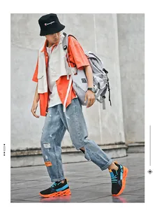 Urban streetwear look with layered orange shirt, grey vest, and blade running shoes