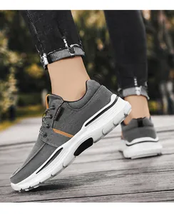 Primer plano de zapato de lona gris con detalles naranjas y suela de goma blanca