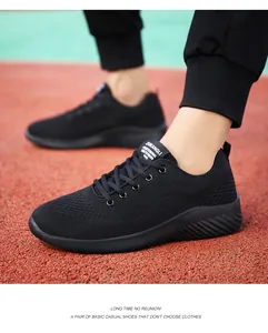 Vista lateral de zapatillas de running negras de punto para hombre en una pista roja