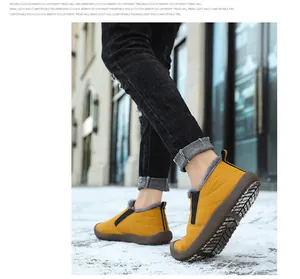 Close-up of yellow waterproof winter boots with fur lining walking on outdoor snow