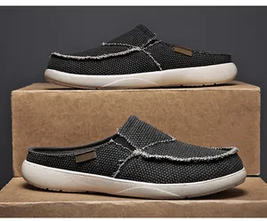Detaillierte Nahaufnahme schwarzer Canvas-Mules mit Vintage-Fransenkanten und dicker weißer Sohle