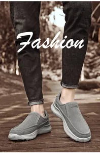 Détail de mocassins en toile rayée grise pour hommes avec semelles sur sol en bois