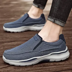 Chaussures en toile bleu marine sans lacets pour hommes sur un sol en bois