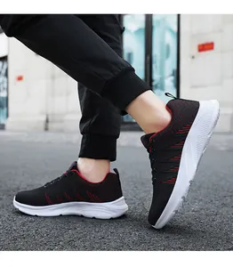 Foto dinámica de zapatillas running hombre negras con costuras rojas y suela de EVA blanca
