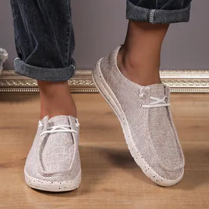 Detail showing khaki canvas loafers with woven texture and speckled sole on model