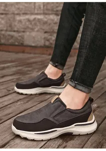 On-foot view of brown leather slip-on shoes with classic text and thick white rubber sole