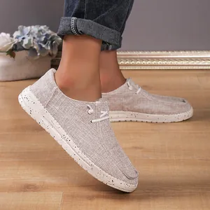 Detail of light beige canvas loafers featuring a textured upper and speckled rubber sole