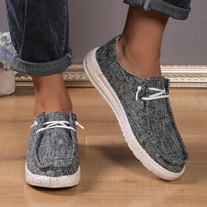 Detail of grey textured canvas loafers with speckled platform soles on wooden floor