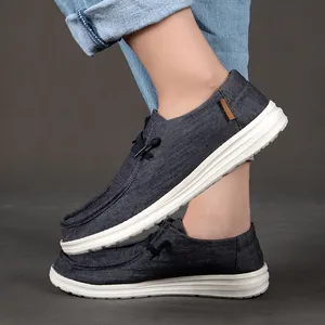 Dettaglio di mocassini in tela denim grigia con suola bianca e inserti in cuoio