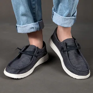 Dettaglio dei mocassini slip-on in tela grigio scuro con suola bianca spessa antiscivolo