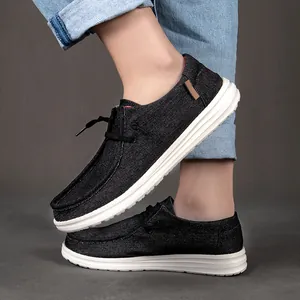 Dettaglio di mocassini in tela nera da uomo con trama denim e suola in gomma bianca