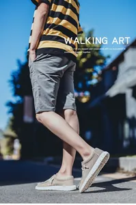 Outdoor street view of men's khaki canvas loafers with striped t-shirt and grey shorts