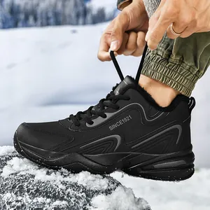 Détail de chaussures de sport d'hiver noires doublées polaire, lacées dans un décor de neige
