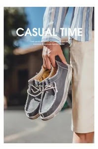 Detalle de mocasines de lona gris con bordes deshilachados y cordones blancos decorativos