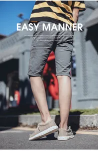 Outdoor street view of men's casual grey shorts and beige chunky canvas shoes