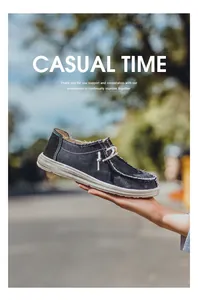 Detalle de mocasines de lona negra para hombre con costuras y suela blanca gruesa