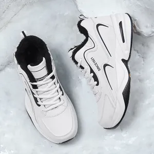 Vue détaillée de chaussures de course en cuir blanc avec doublure polaire noire sur neige