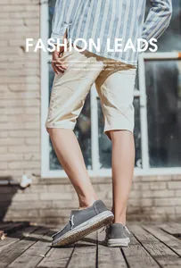 Detalle de mocasines de lona gris para hombre con bordes deshilachados y suela blanca gruesa