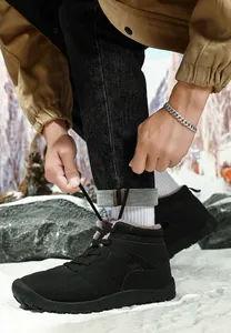 Outdoor snow scene of high-top winter boots for men featuring thick warm grey fur lining