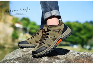 Nahaufnahme olivgrüner Wanderschuhe aus Wildleder mit rutschfesten Gummisohlen auf Fels