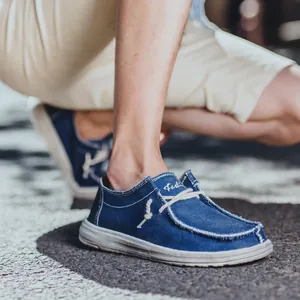 Heren instappers van donkerblauw canvas met gerafelde randen en borduursels