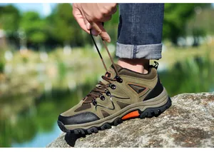 Nahaufnahme beim Schnüren brauner Wanderschuhe mit rutschfester Gummisohle