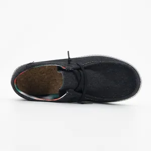 Vista dall'alto di mocassini in denim nero con fodera a righe e soletta in sughero