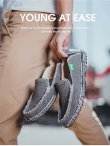 Detail eines grauen Canvas-Loafers mit gewebter Sohlennähte und grünem Mode-Etikett