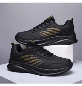Detail eines schwarzen Kunstleder-Sneakers mit goldenem Feder-Motiv und Gummisohle