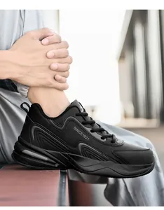 Détail de baskets en cuir noir montrant des lignes ondulées et un talon amortissant