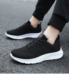 Close-up of breathable black mesh sneakers with thick white soles and wave side detail
