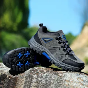 Outdoor-Wanderschuhe aus grauem Wildleder und Mesh auf felsigem Grund mit Gummisohlen