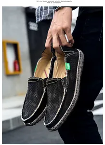 Détail de mocassins noirs respirants pour hommes avec étiquette FASHION verte et coutures main