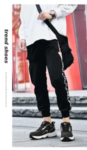 Vue street style d'un jogging noir avec bandes latérales et baskets compensées noir et blanc
