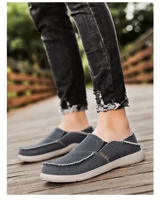Detail of dark grey canvas loafers with frayed edges and thick cream soles outdoors