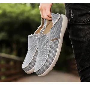Detailed view of light blue slip-on canvas shoes with raw edges and rubber soles