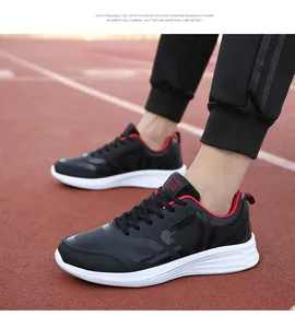 Detailaufnahme der schwarz-roten Herren-Laufschuhe auf einer Leichtathletikbahn