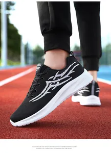 On-foot view of black and white breathable knit sneakers on an outdoor running track
