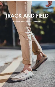 Close-up of beige canvas loafers with frayed edges and green label on outdoor street