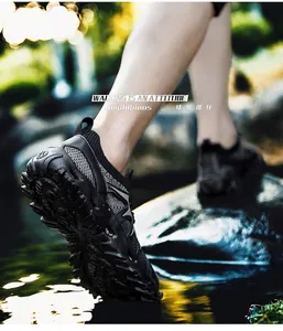 Action shot of men's breathable outdoor wading shoes on wet rocks for hiking