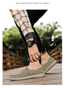 Close-up of olive green canvas loafers with breathable fabric on a wooden path