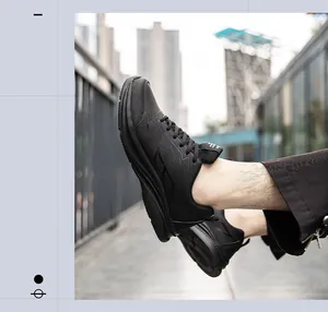 Nahaufnahme schwarzer Kunstleder-Sneaker mit dicken rutschfesten Sohlen und Schnürdesign