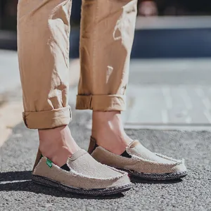 Beige Canvas Loafer für Herren mit Fransenkante und Modeetikett auf Asphaltboden