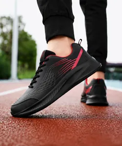 Detailopname van zwarte en rode hardloopschoenen met dempende zool op een atletiekbaan