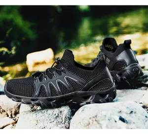 Detail of black outdoor wading shoe with breathable mesh and quick-lace system on a rock